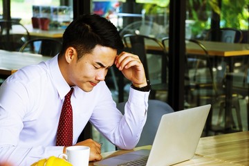 Office man is working remote from coffee shop to his office by using wifi in cafe