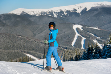 Fototapeta na wymiar Full length shot of a happy woman skiing in the mountains at ski resort copyspace happiness enjoyment activity recreation winter seasonal sports concept