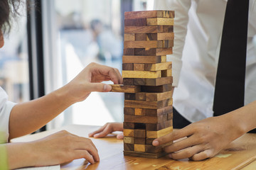 Alternative risk concept, plan and strategy in business, Risk To Make Buiness Growth Concept With Wooden Blocks, Images of hand of businesspeople placing and pulling wood block on the tower.	