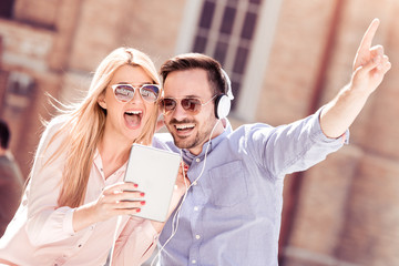 Couple listening to music on tablet in the city