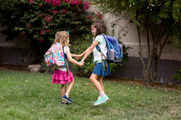 Obraz premium Two girls are playing excitedly and anxiously before their first day of school. 