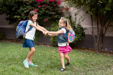 Naklejka premium Two girls are playing excitedly and anxiously before their first day of school. 