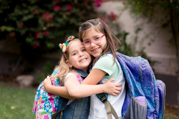 Two girls are playing excitedly and anxiously before their first day of school. 