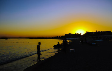 Naklejka na ściany i meble silhouette on the beach at sunset