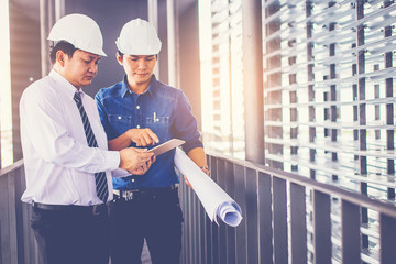 contractor and engineer with blueprints discuss at a modern construction site, Architecture and Engineering concept.