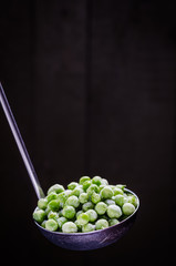 frozen green peas in a spoon