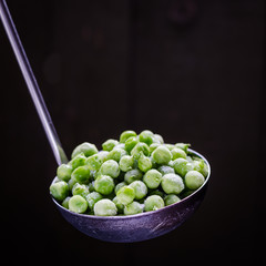 frozen green peas in a spoon