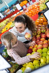 Fototapeta na wymiar Mother and daughter buying apples .