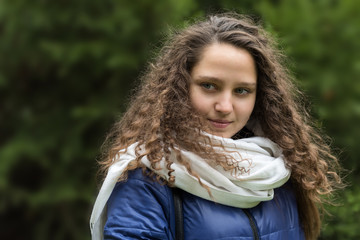 Girl with curly hair against a background of autumn foliage