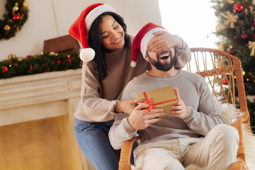 Obraz na płótnie Canvas Loving wife giving her husband Christmas present