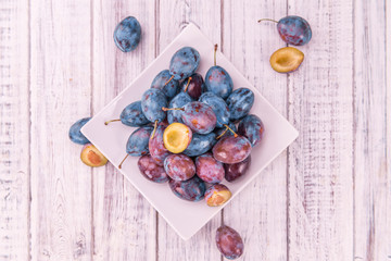 Portion of Plums on wooden background, selective focus