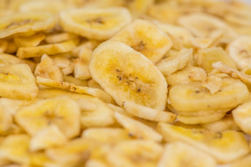 Obraz na płótnie Canvas Portion of Dried Banana Chips on wooden background, selective focus