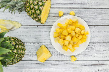 Portion of Pineapple (sliced) on wooden background, selective focus