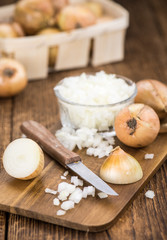 White Onions (dices) on wooden background; selective focus