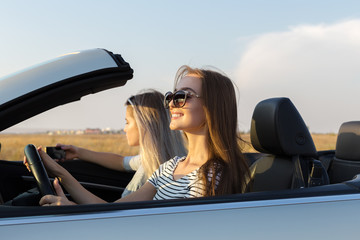 Two attractive young women in a cabriolet car