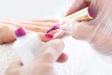 Obraz na płótnie Canvas Manicure żelowy, kosmetyczka przedłuża paznokcie. Zabieg pielęgnacyjny dłoni i paznokci, kobieta u kosmetyczki na zabiegu manicure.