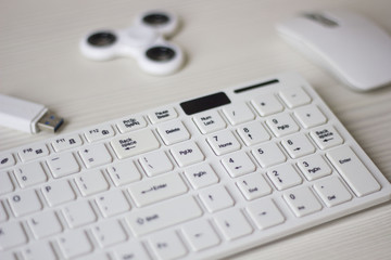 white computer mouse, spinner, flash card and keyboard on a white table, business concept