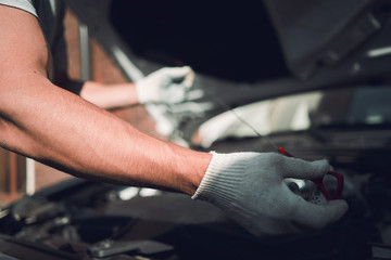 Close-up. The man is fixing the car. Checks engine oil level