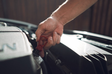 Close-up. The man is fixing the car. Checks engine oil level