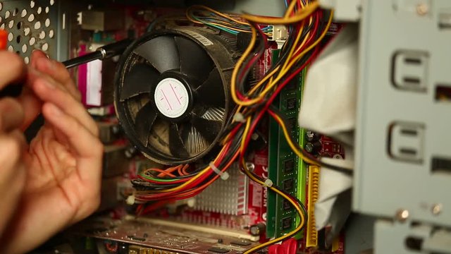 Serviceman disassembles the processor cooler in the computer