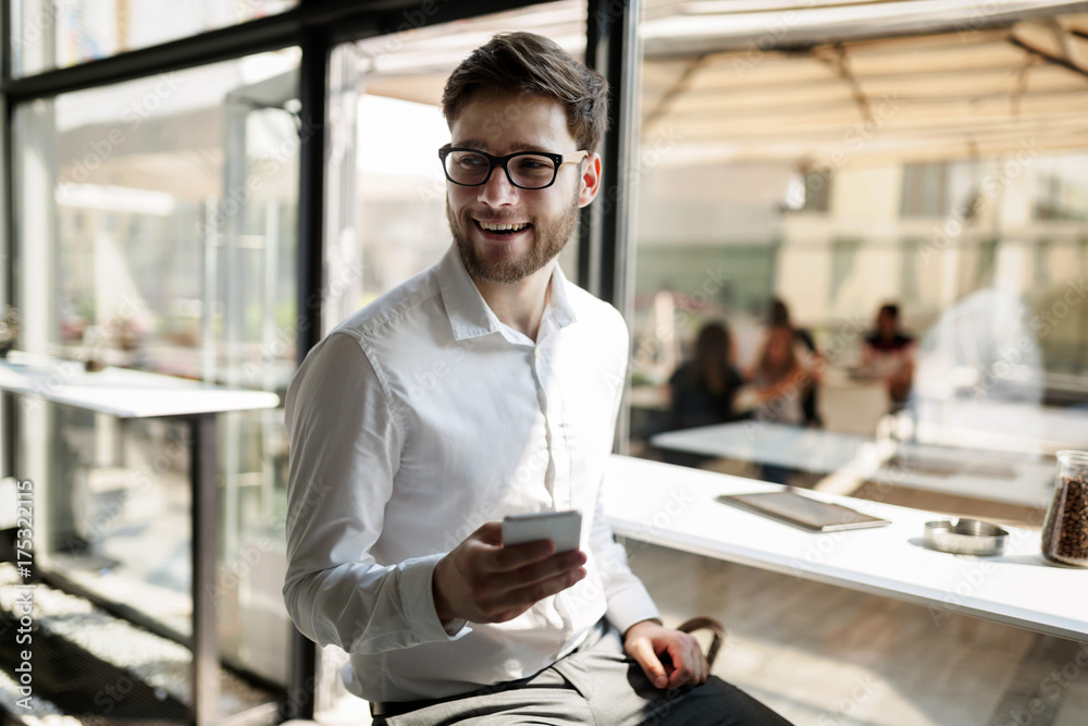 Sticker Businessman holding mobile device in cafe