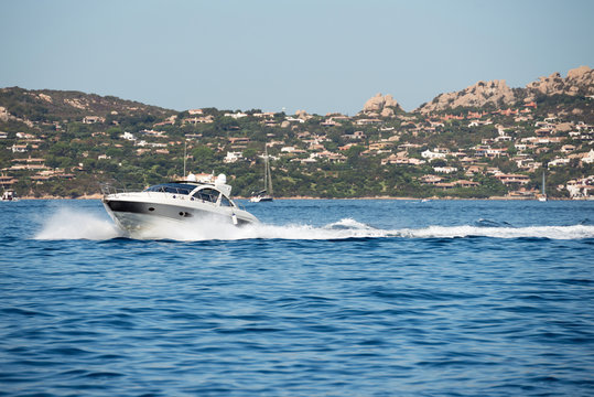Small motor boat on sea, Sardinia island in background