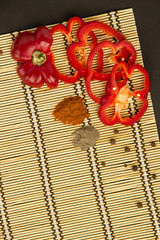 Several ripe red peppers sweet and hot and pepper peas on a napkin on a black background