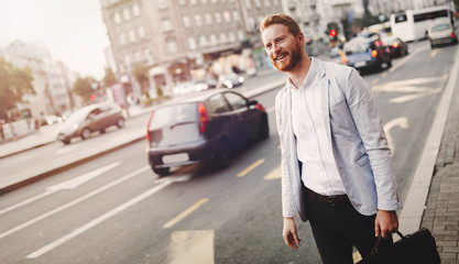 Businessman downtown next to busy road