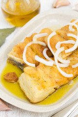 fried cod fish with onion and olive oil on dish