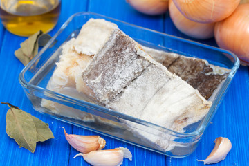 dry cod fish with onion on wooden background
