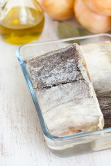 dry cod fish with onion on wooden background