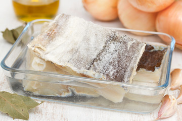 dry cod fish with onion on wooden background