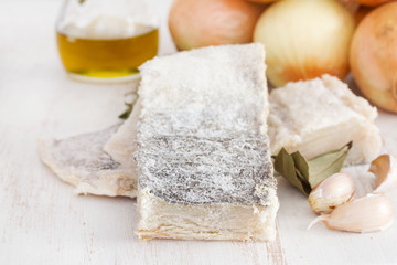 dry cod fish with onion on wooden background