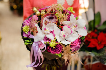 Colorful winter bouquet of beautiful flowers in woman hands