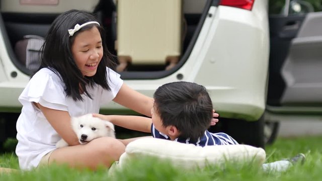 Asian children playing with siberian husky puppy in the park 4k 9