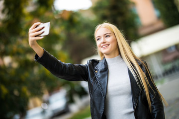 Portrait of a young beautiful woman student video call, selfie, holding a phone.