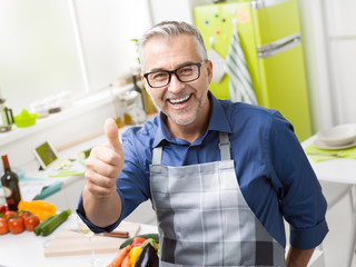 Confident smiling man posing in his kitchen