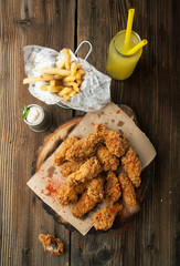 Fried wings with sauce and lemonade on a wooden board