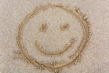 Smiley face drawn in the sand from above