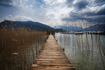 Fototapeta premium Drewniany pomost z bramą w jeziorze tegernsee, słynny ośrodek turystyczny w Alpach Bawarskich, Niemcy, Europa
