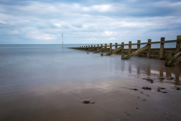Fototapeta na wymiar Long exposure at Portobello beach with groynes and a calm sea