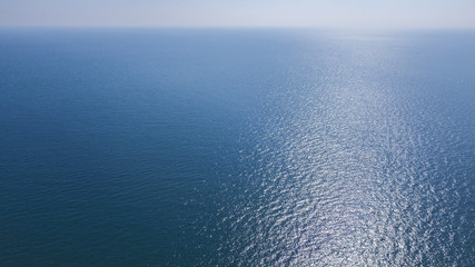 Vista aerea delle acque blu del mar Mediterraneo e nello specifico del mar Tirreno. La luce del sole si riflette sulla superficie dell'acqua. - obrazy, fototapety, plakaty