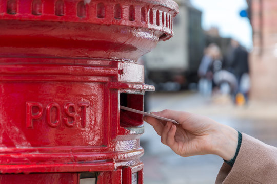Throwing a letter in a red British post box