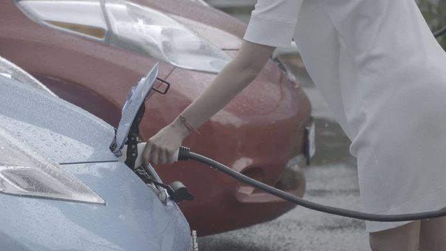 Woman removes charging cable out of her car - slog3