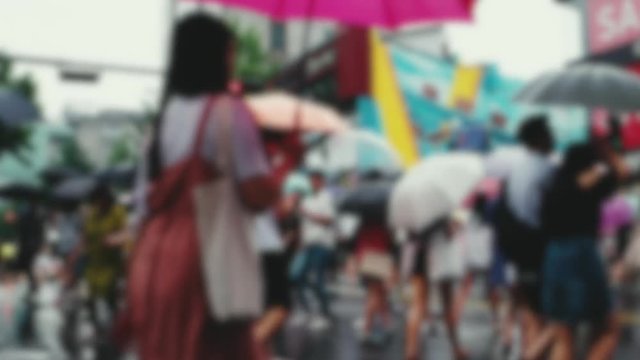 People on cross walk with umbrellas on a rainy day at Hongdae shopping district. Seoul 2017. 4K resolution