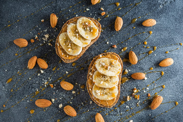 Sandwiches with peanut butter, banana, nuts and caramel. Diet natural breakfast. Flat lay, top view