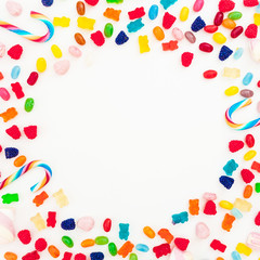 Round frame with assorted colored candies on white background. Sugary concept. Flat lay, top view