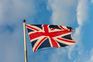 The flag of the United Kingdom on a pole and blue sky