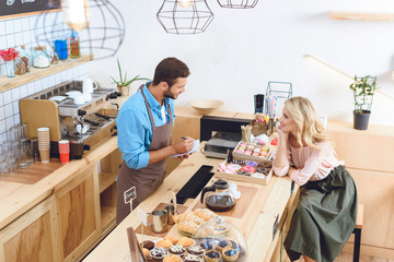 waiter with notebook and smiling woman