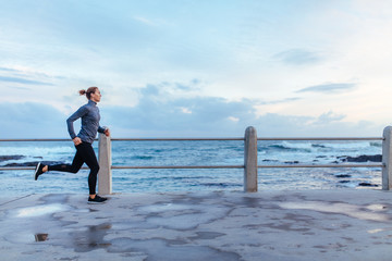 Female runner running on seaside promenade